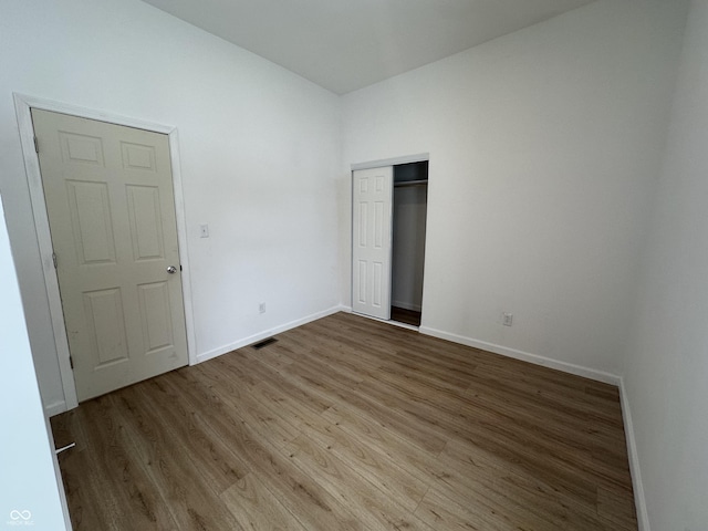 unfurnished bedroom featuring light hardwood / wood-style floors and a closet