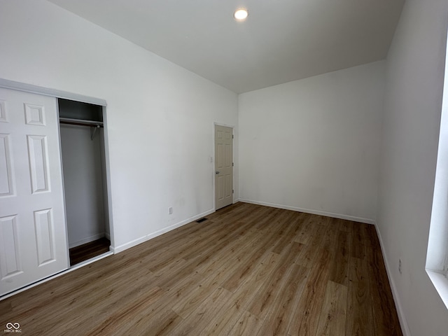 unfurnished bedroom featuring light wood-type flooring and a closet