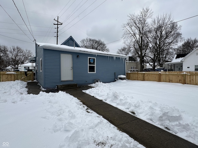 view of snow covered back of property