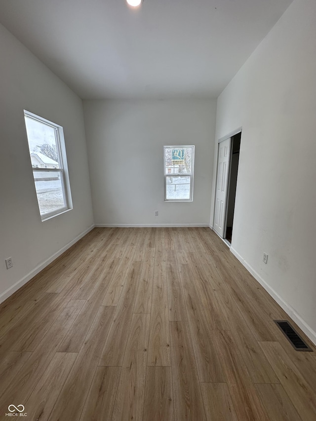 empty room with light hardwood / wood-style flooring