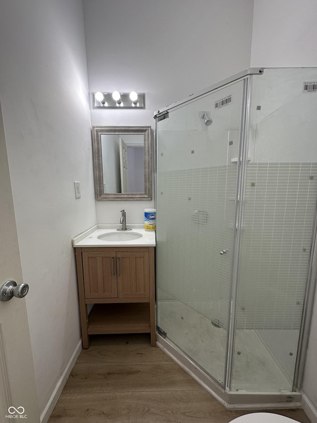 bathroom featuring hardwood / wood-style floors, vanity, and walk in shower