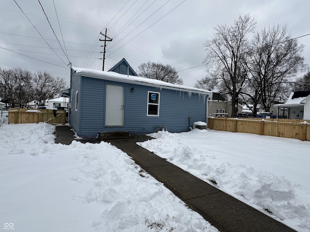 view of snow covered back of property