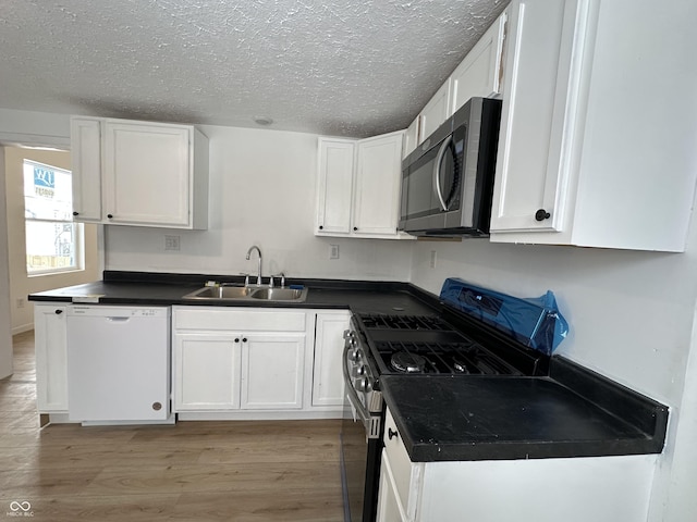 kitchen featuring white cabinetry, sink, light wood-type flooring, and appliances with stainless steel finishes