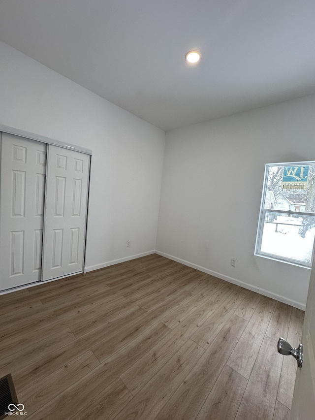 unfurnished bedroom with a closet and wood-type flooring