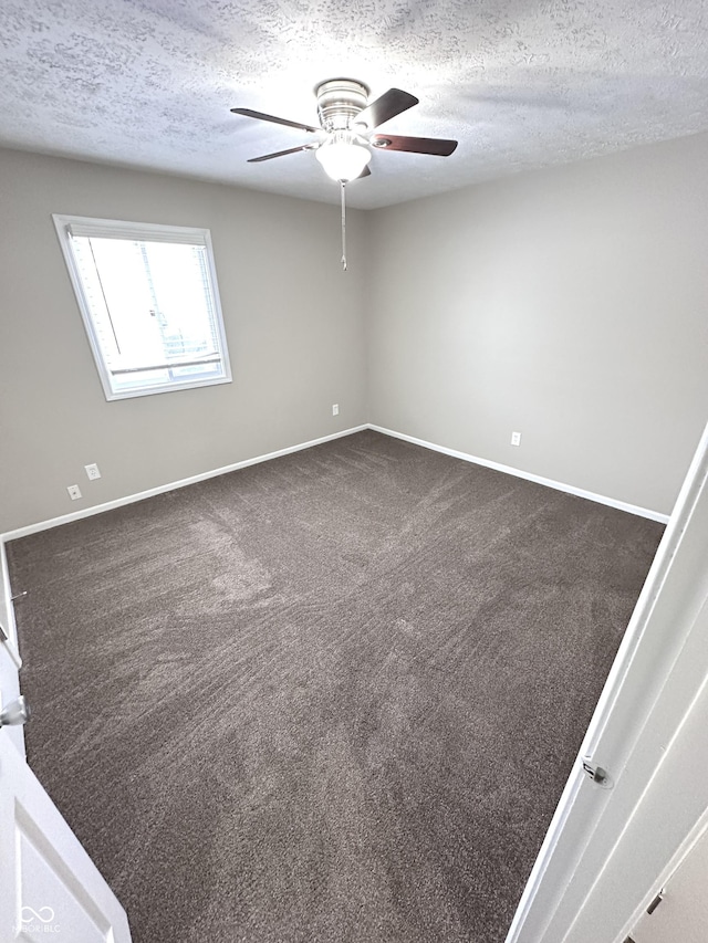 carpeted empty room featuring ceiling fan and a textured ceiling