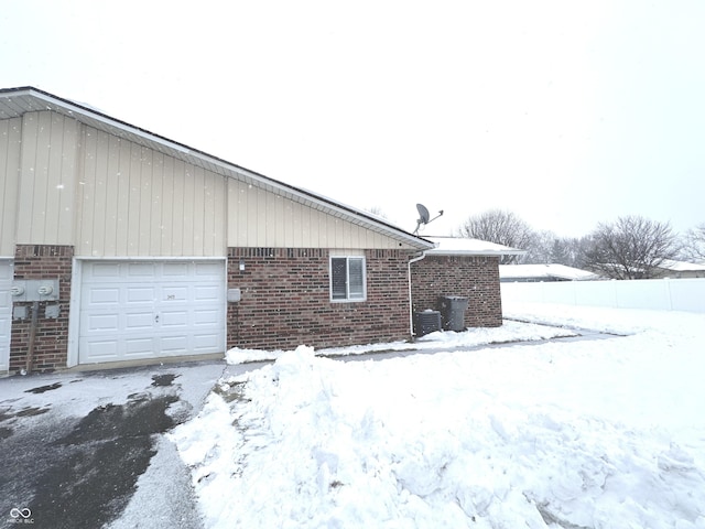 view of snow covered exterior with a garage