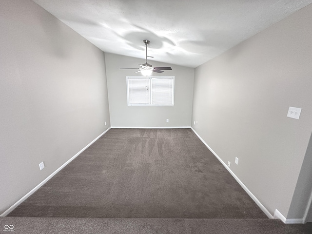 unfurnished dining area with ceiling fan, dark carpet, and lofted ceiling