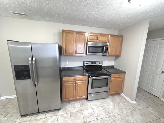 kitchen with stainless steel appliances and a textured ceiling