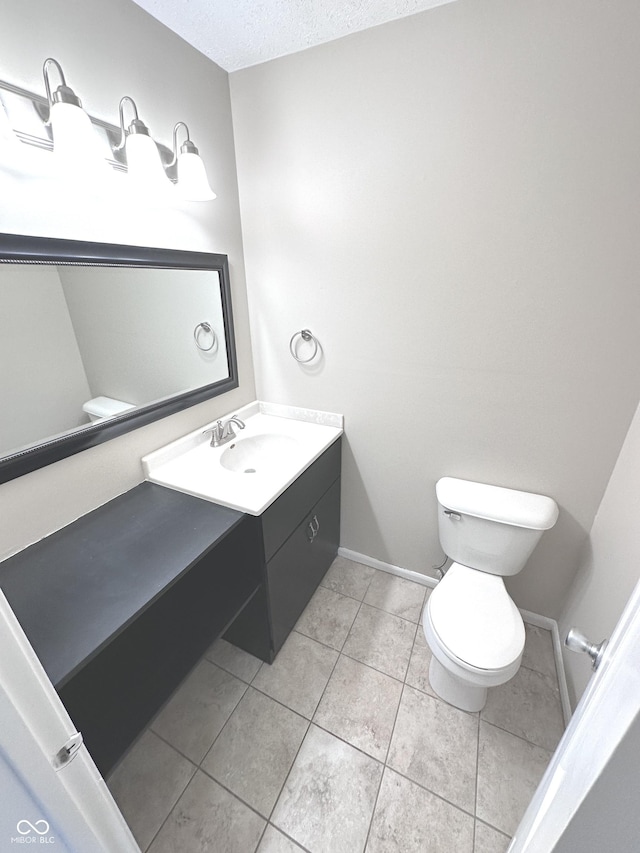 bathroom featuring tile patterned floors, vanity, toilet, and a textured ceiling