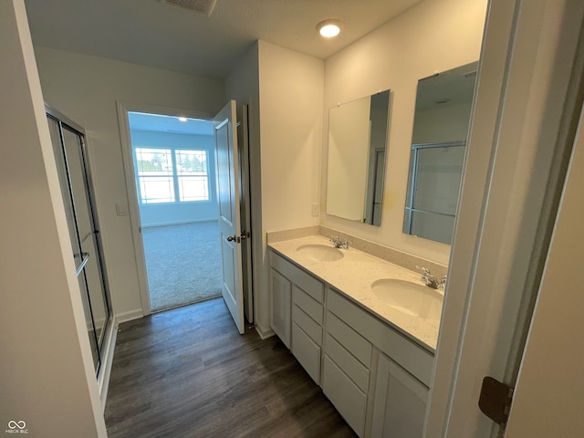 bathroom with hardwood / wood-style flooring, vanity, and walk in shower