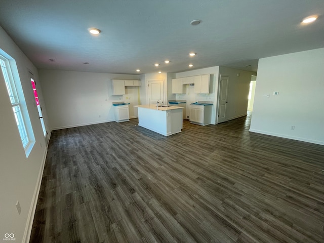 kitchen featuring white cabinetry, a center island with sink, dark wood-type flooring, and sink