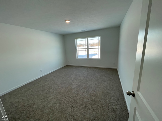 empty room featuring dark carpet