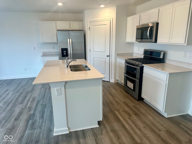 kitchen featuring stainless steel appliances, dark wood finished floors, a sink, and white cabinetry