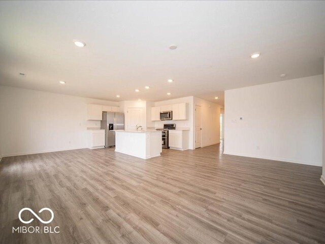 6618 Sulgrove Pl, Indianapolis, IN 46221 - unfurnished living room with recessed lighting, baseboards, and light wood-type flooring