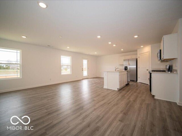 6618 Sulgrove Pl, Indianapolis, IN 46221 - unfurnished living room featuring baseboards, dark wood-style flooring, a wealth of natural light, and recessed lighting
