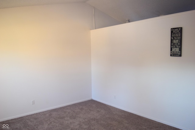 carpeted spare room with lofted ceiling