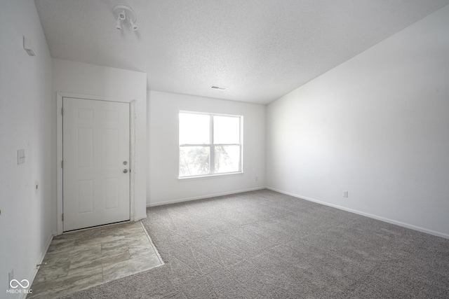 spare room with carpet floors and a textured ceiling