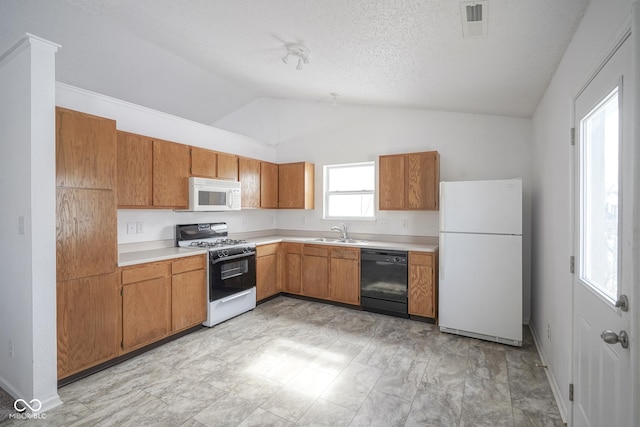 kitchen with white appliances, vaulted ceiling, sink, and a textured ceiling