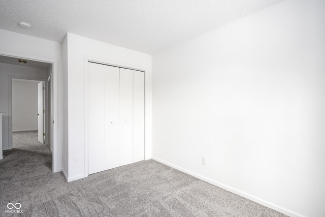 unfurnished bedroom with a closet, carpet flooring, and a textured ceiling