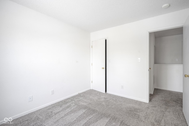 unfurnished bedroom featuring a textured ceiling and light colored carpet