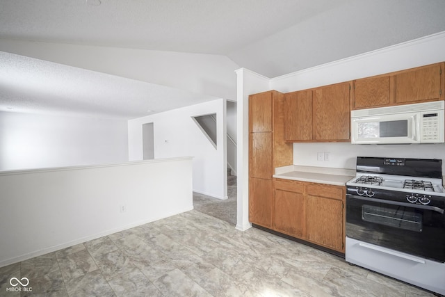 kitchen featuring vaulted ceiling, gas stove, and a textured ceiling