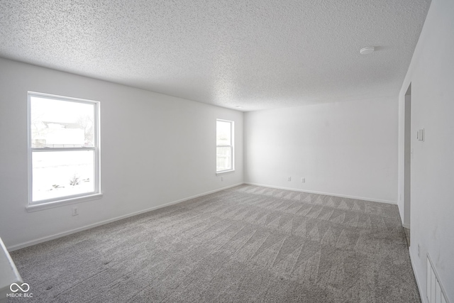 carpeted spare room with a textured ceiling