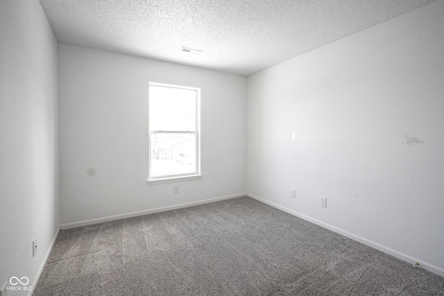 carpeted spare room featuring a textured ceiling