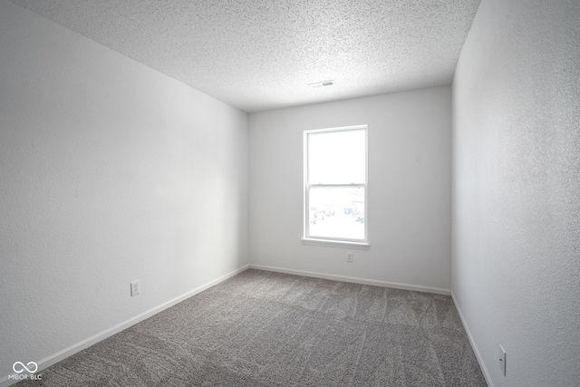 carpeted spare room featuring a textured ceiling