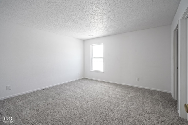 carpeted spare room featuring a textured ceiling