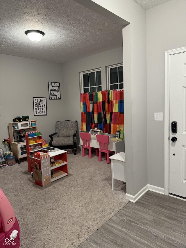 game room with a textured ceiling and hardwood / wood-style floors