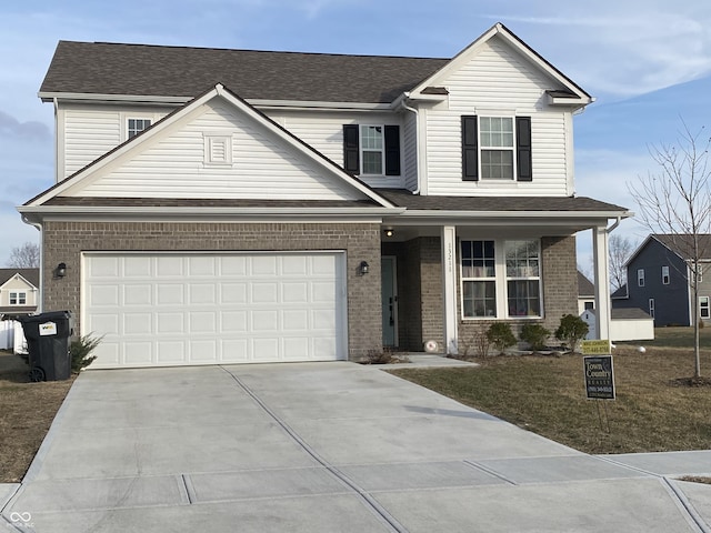 view of property featuring a garage and a front yard