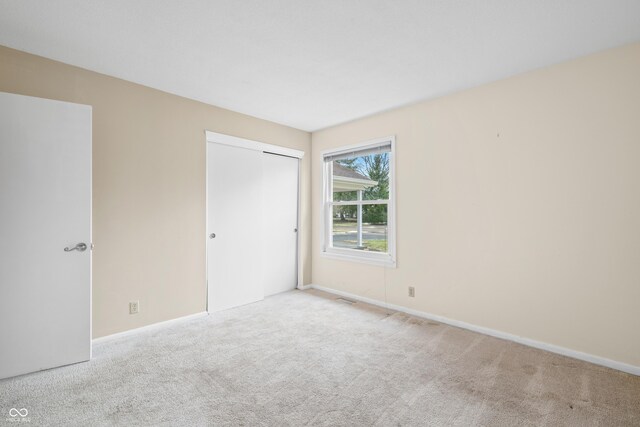 unfurnished bedroom with a closet, carpet, and baseboards