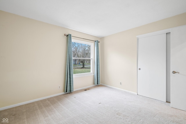 spare room featuring carpet floors, baseboards, and visible vents