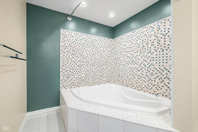 bathroom featuring baseboards, a bath, and tile patterned floors