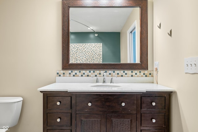 bathroom with toilet, decorative backsplash, and vanity