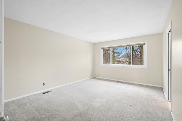 unfurnished room with baseboards, visible vents, and carpet flooring