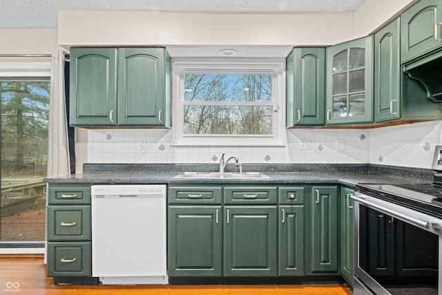 kitchen featuring stainless steel electric range oven, white dishwasher, a sink, and green cabinetry