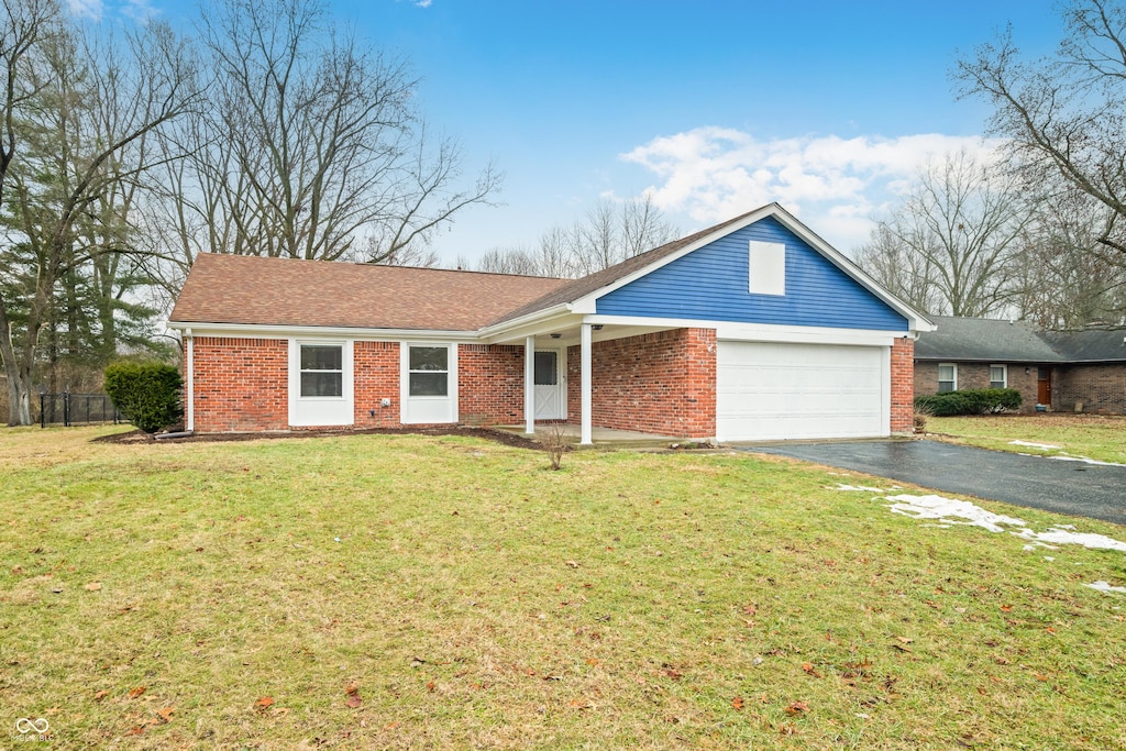 single story home with a garage and a front lawn