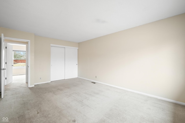 unfurnished bedroom with carpet, a closet, visible vents, and baseboards