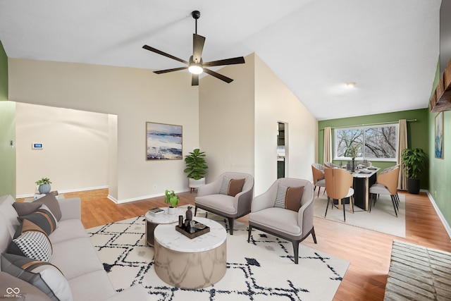 living room with high vaulted ceiling, a ceiling fan, baseboards, and wood finished floors