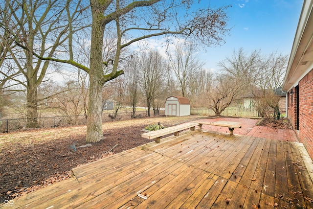 deck featuring a shed, a fenced backyard, and an outdoor structure