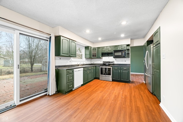 kitchen featuring light wood-style flooring, appliances with stainless steel finishes, and green cabinetry