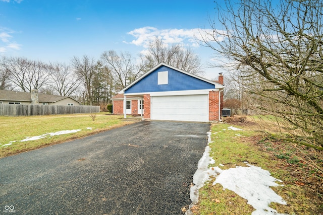 view of front of property with a garage, brick siding, fence, driveway, and a chimney