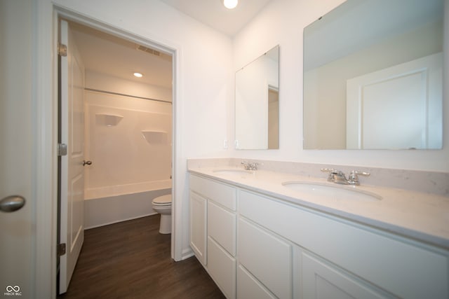 full bathroom with washtub / shower combination, wood-type flooring, toilet, and vanity