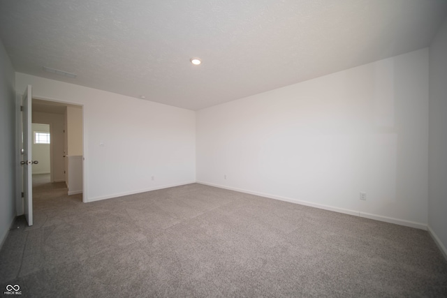 carpeted spare room featuring a textured ceiling