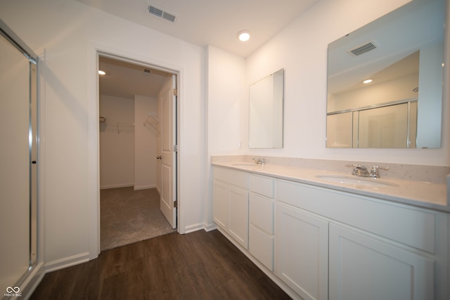 bathroom with hardwood / wood-style flooring, vanity, and an enclosed shower