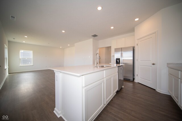 kitchen with white cabinetry, sink, stainless steel appliances, and an island with sink