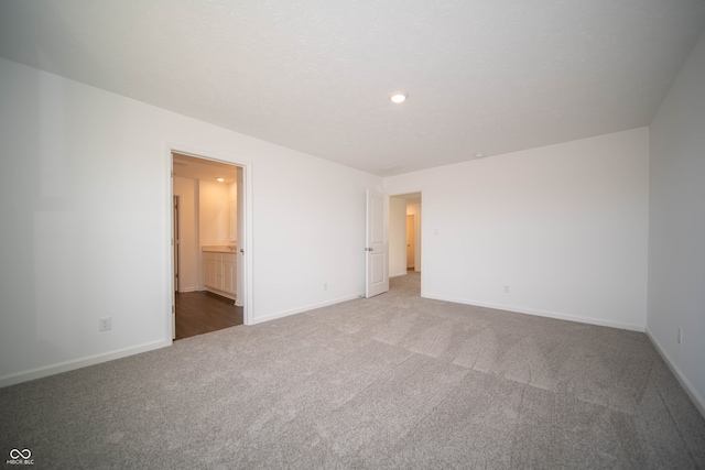 unfurnished bedroom featuring connected bathroom and carpet