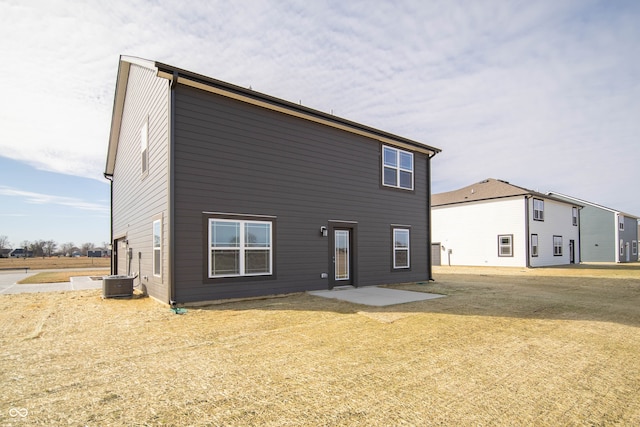 back of house featuring central AC, a patio area, and a lawn