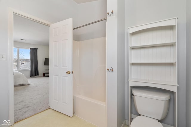 bathroom with washtub / shower combination and toilet